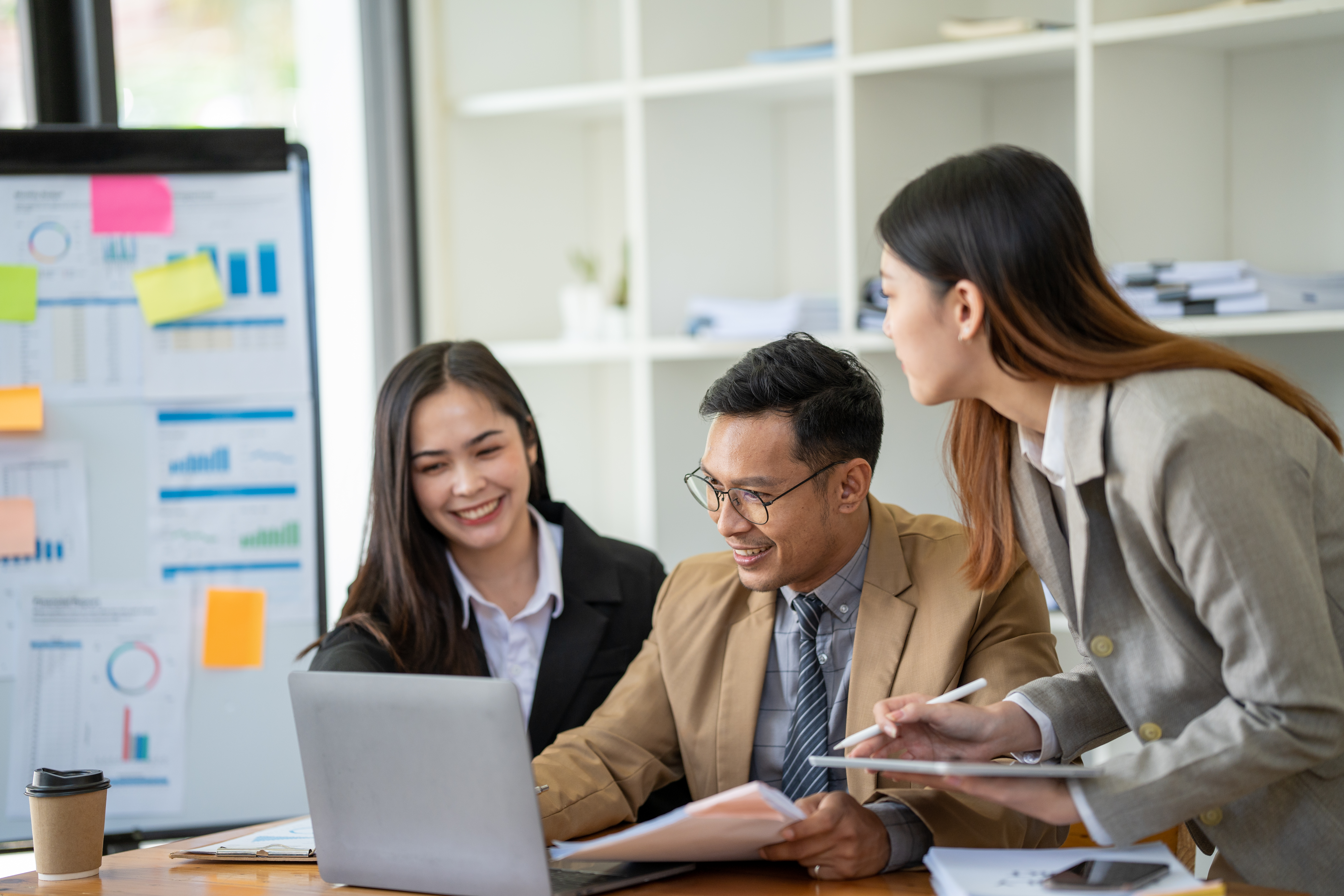 people working around a laptop