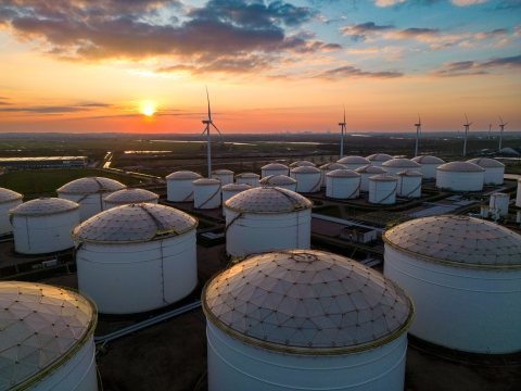 Aerial shot of the sunset behind an oil field fill