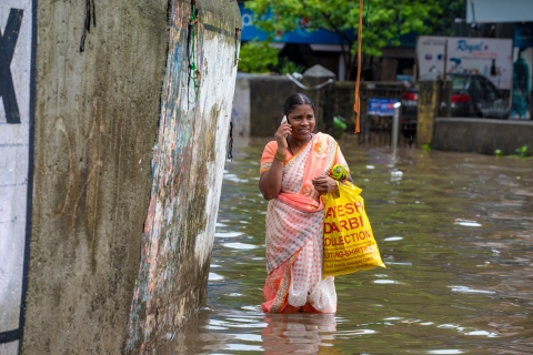 Woman talking on a phone on a flooded street