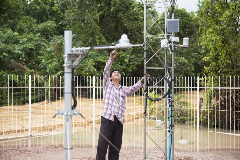 A person checking a weather station