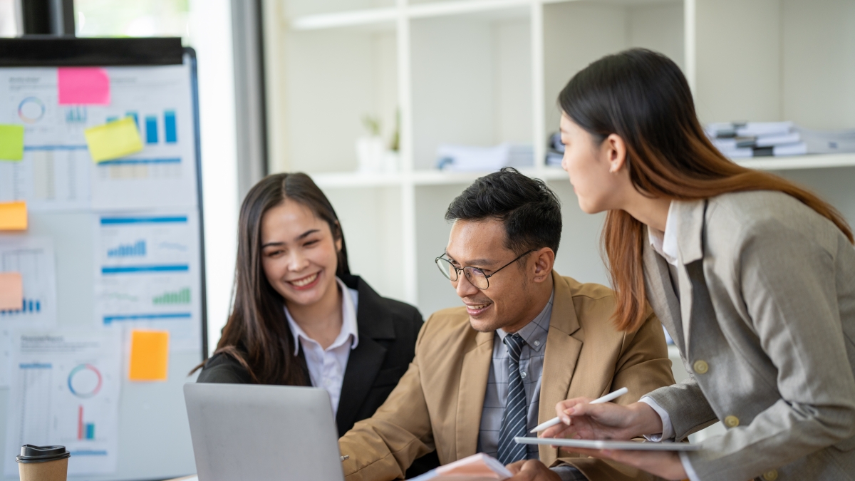 people working around a laptop